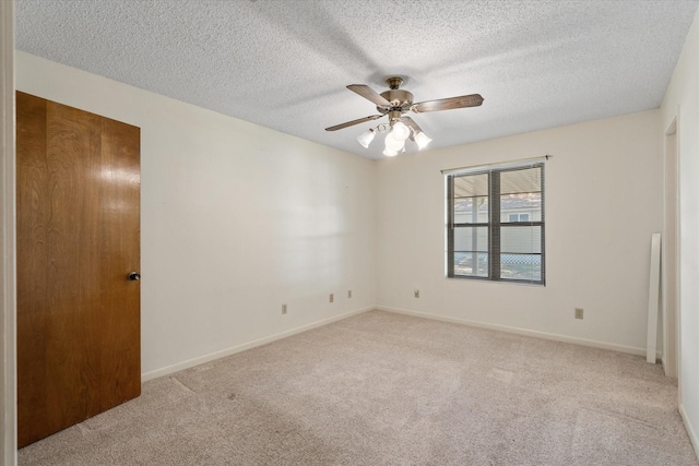 carpeted empty room featuring ceiling fan and a textured ceiling