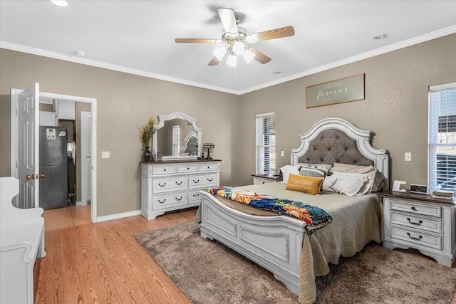 bedroom featuring crown molding, light hardwood / wood-style floors, and ceiling fan