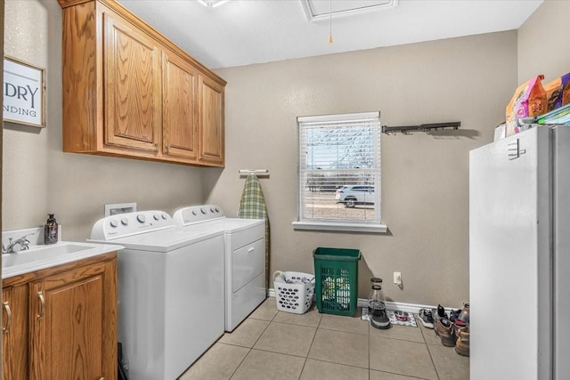 laundry room with sink, washer and clothes dryer, cabinets, and light tile patterned flooring