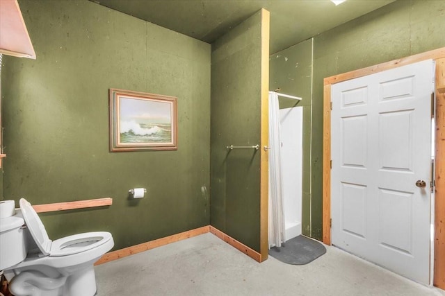 bathroom with toilet, concrete flooring, and a shower