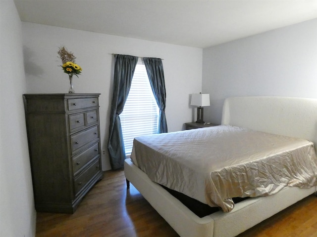 bedroom with dark wood-type flooring