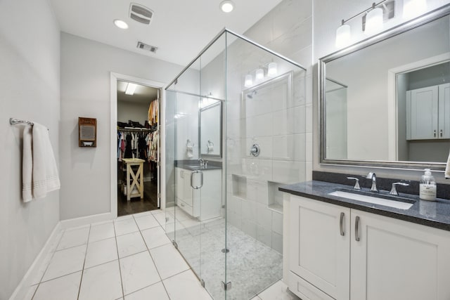 bathroom with vanity, a shower with door, and tile patterned flooring