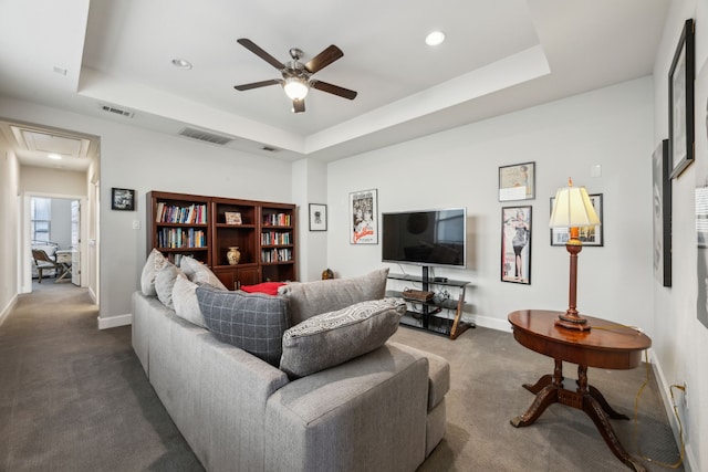 living room with ceiling fan, a raised ceiling, and carpet floors