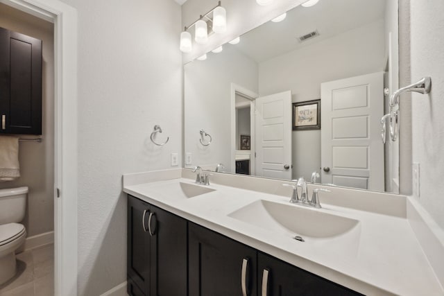 bathroom featuring tile patterned floors, toilet, and vanity