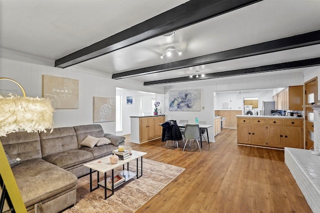 living room with light hardwood / wood-style flooring and beamed ceiling