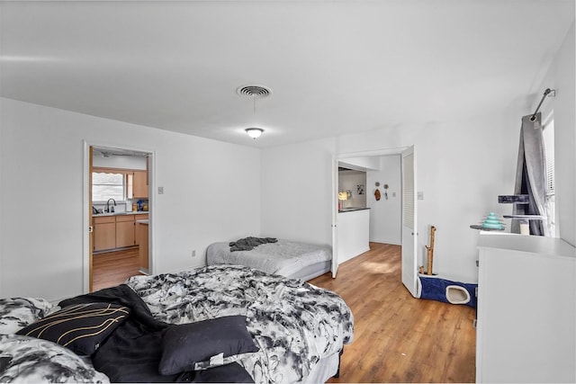 bedroom featuring sink and hardwood / wood-style floors