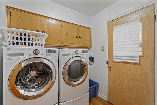 laundry area featuring light wood-type flooring, cabinets, and separate washer and dryer