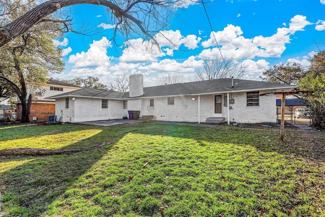 rear view of house featuring central AC unit, a yard, and a patio