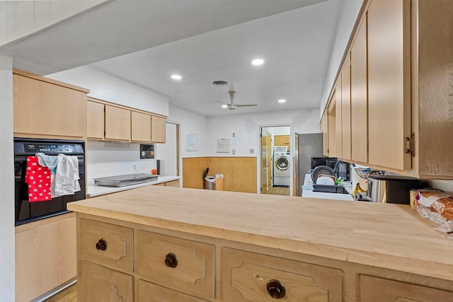 kitchen featuring black appliances, butcher block counters, washer / clothes dryer, kitchen peninsula, and ceiling fan