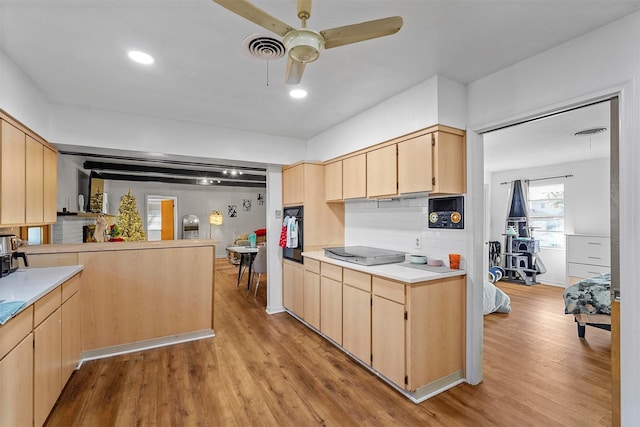 kitchen with light brown cabinetry, ceiling fan, tasteful backsplash, light hardwood / wood-style floors, and black appliances