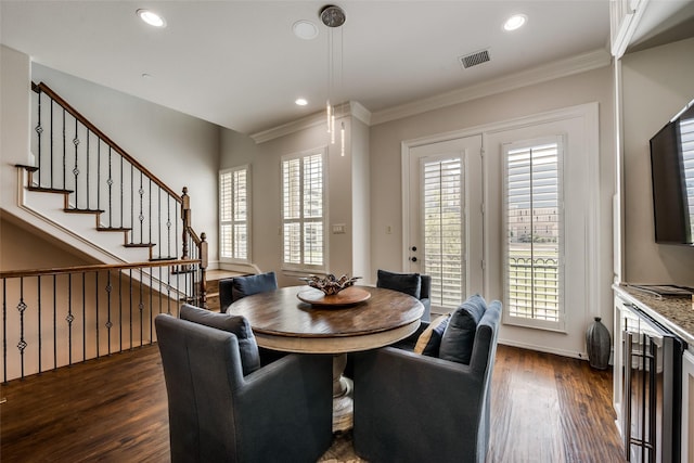 dining space with a healthy amount of sunlight, ornamental molding, and dark hardwood / wood-style floors