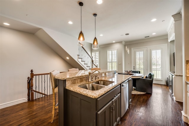 kitchen featuring sink, a kitchen island with sink, hanging light fixtures, dark hardwood / wood-style floors, and stainless steel dishwasher