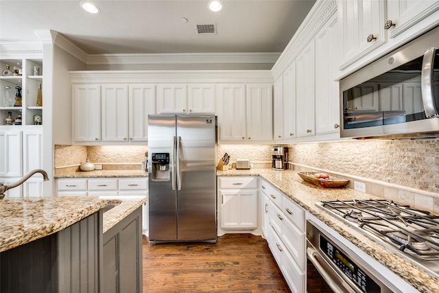 kitchen with crown molding, appliances with stainless steel finishes, dark hardwood / wood-style flooring, light stone countertops, and white cabinets