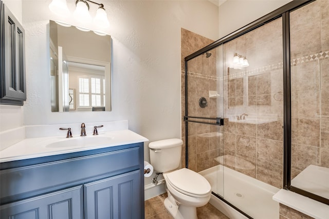 bathroom with vanity, toilet, and a shower with door