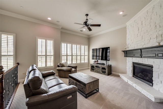 carpeted living room with ornamental molding, a stone fireplace, and ceiling fan