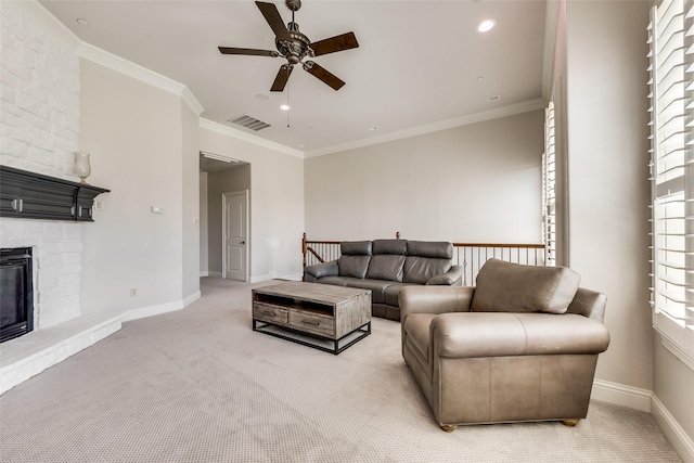 carpeted living room featuring ceiling fan, ornamental molding, a fireplace, and a wealth of natural light