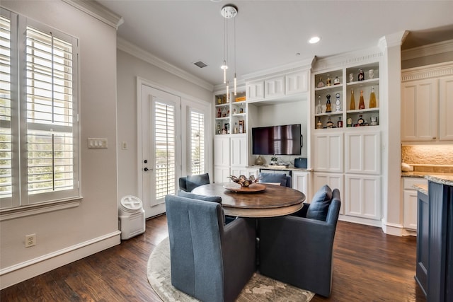 dining space with crown molding, dark wood-type flooring, and built in features