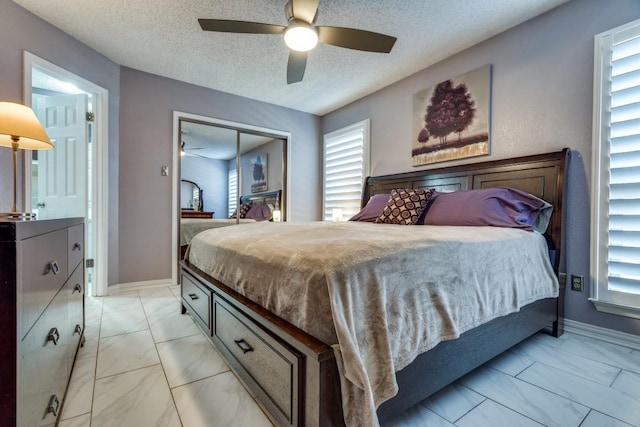 bedroom featuring a closet, ceiling fan, and a textured ceiling