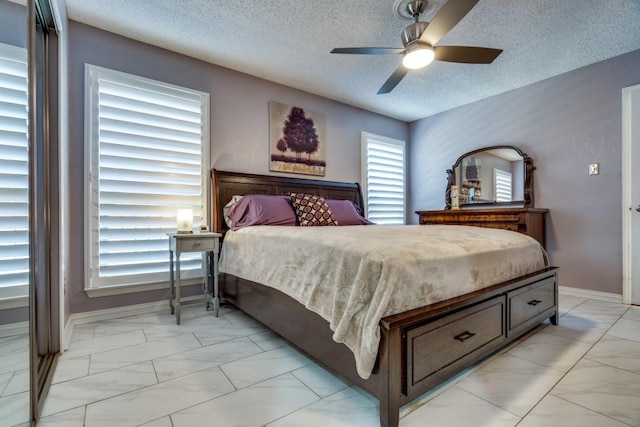 bedroom featuring ceiling fan and a textured ceiling