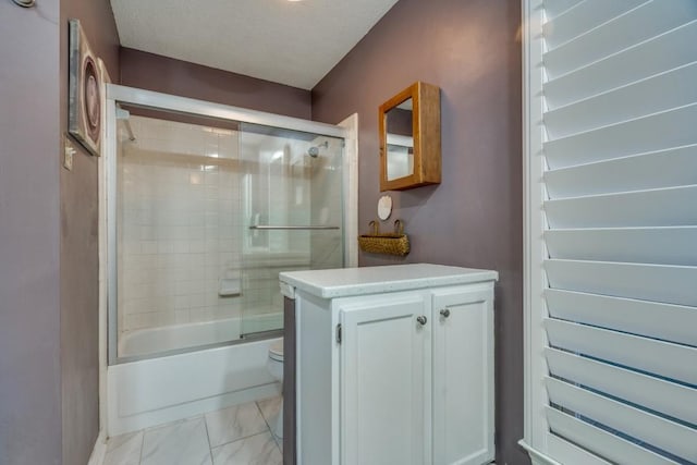 bathroom featuring combined bath / shower with glass door and a textured ceiling