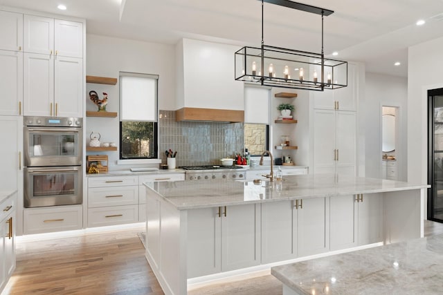 kitchen featuring white cabinets, stainless steel double oven, and sink