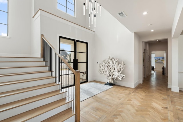 foyer entrance featuring a high ceiling and light parquet flooring