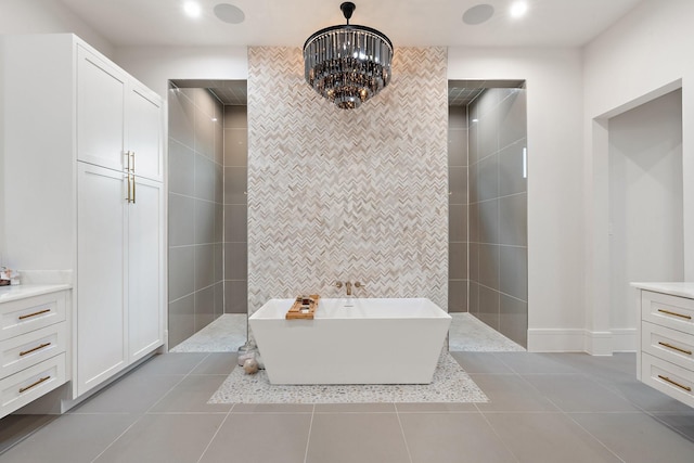 bathroom with tile patterned floors, vanity, tile walls, a notable chandelier, and separate shower and tub