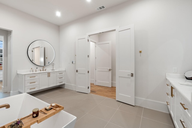 bathroom with a bathtub, tile patterned floors, and vanity