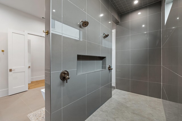 bathroom featuring tile patterned floors and a tile shower