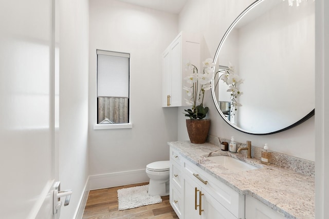 bathroom featuring wood-type flooring, toilet, and vanity