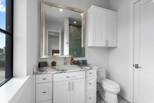 bathroom featuring vanity, a shower with shower door, and toilet