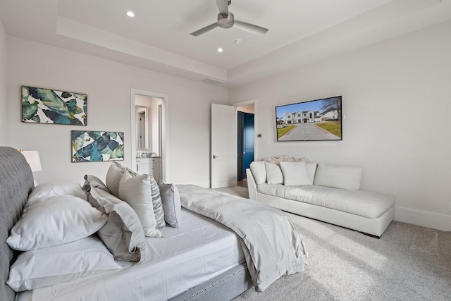 carpeted bedroom featuring ceiling fan and a raised ceiling