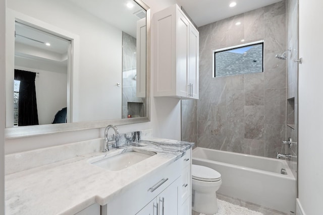 full bathroom featuring toilet, tiled shower / bath, and vanity