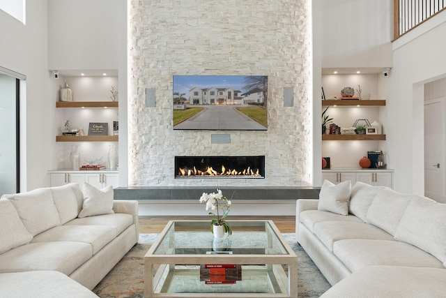 living room featuring a high ceiling, hardwood / wood-style floors, and a fireplace