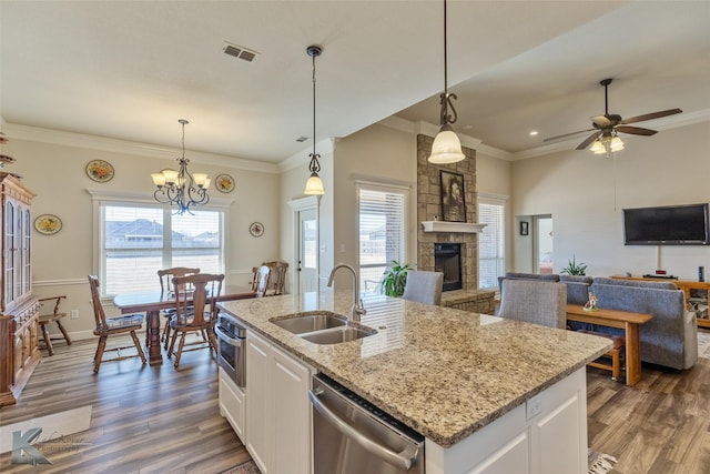 kitchen featuring white cabinetry, appliances with stainless steel finishes, decorative light fixtures, and sink