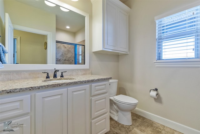 bathroom featuring vanity, an enclosed shower, and toilet