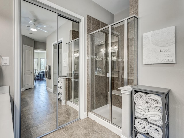 bathroom featuring ceiling fan and a shower with shower door