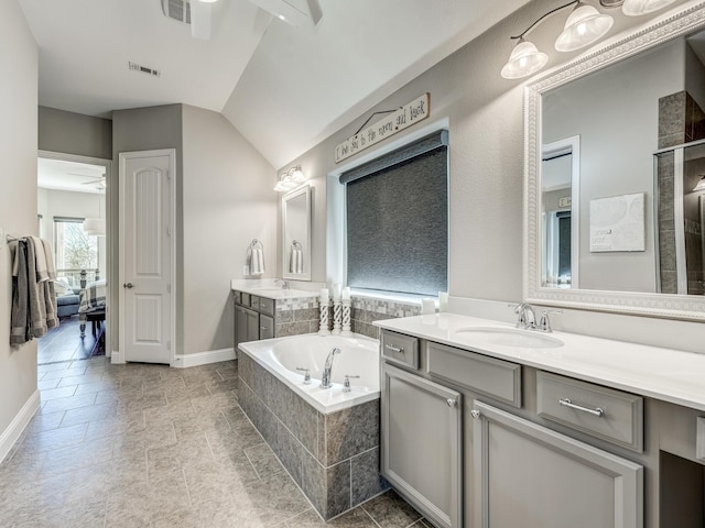 bathroom with ceiling fan, vanity, and tiled tub