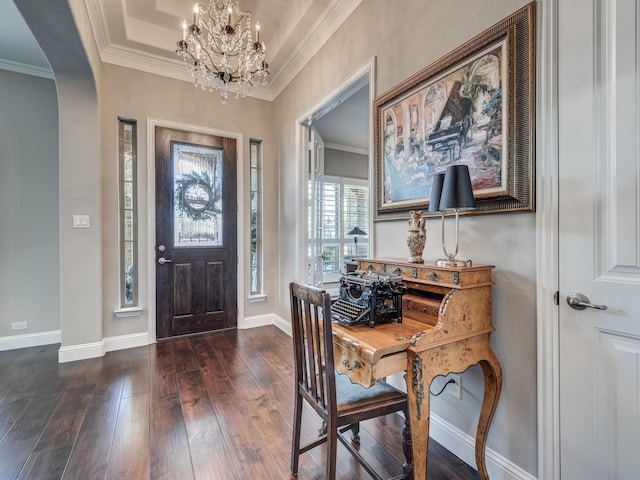 foyer entrance with ornamental molding, dark hardwood / wood-style flooring, a tray ceiling, and a notable chandelier