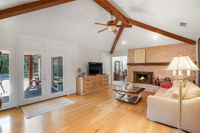 living room featuring a fireplace, beam ceiling, high vaulted ceiling, and light hardwood / wood-style flooring