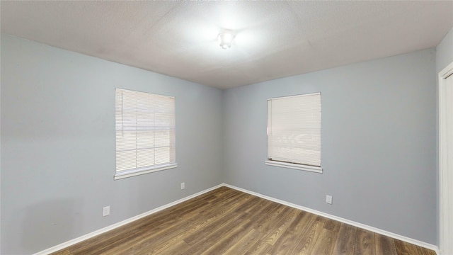 empty room with dark wood-type flooring