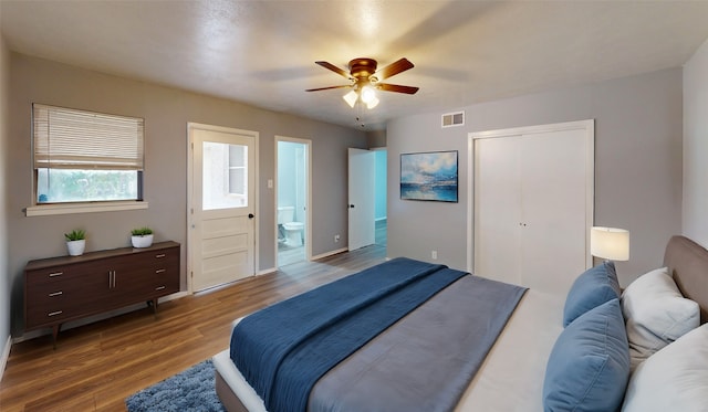 bedroom featuring hardwood / wood-style floors, ensuite bath, and ceiling fan