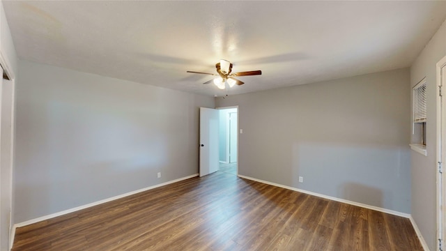 empty room with dark hardwood / wood-style floors and ceiling fan