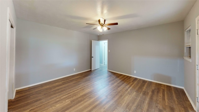 empty room with ceiling fan and dark wood-type flooring