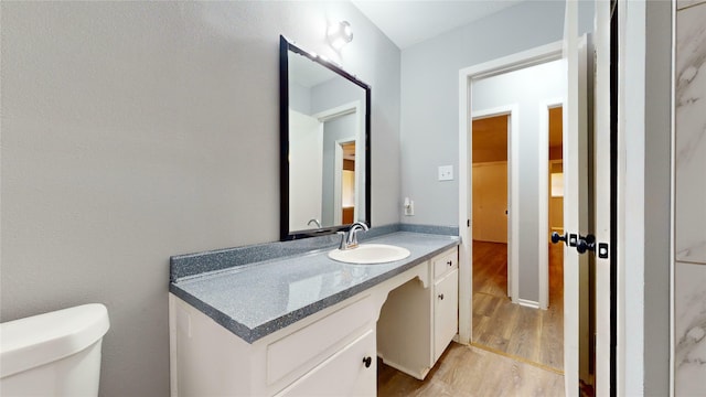 bathroom featuring vanity, toilet, and hardwood / wood-style floors