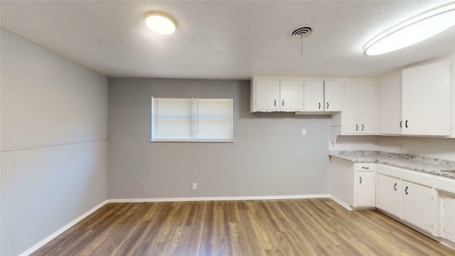 kitchen featuring hardwood / wood-style floors and white cabinetry