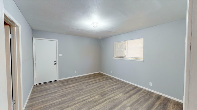 spare room featuring hardwood / wood-style floors and a textured ceiling