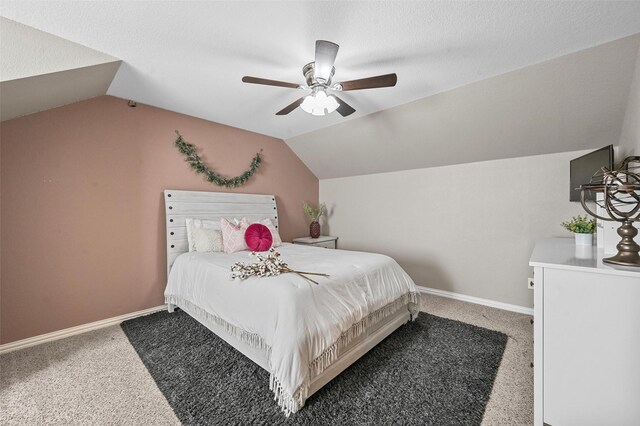 carpeted bedroom with a textured ceiling, vaulted ceiling, and ceiling fan