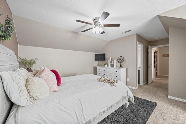 carpeted bedroom featuring vaulted ceiling, a textured ceiling, and ceiling fan