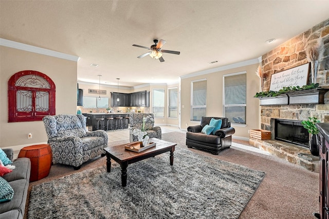 living room with crown molding, ceiling fan, carpet flooring, a textured ceiling, and a stone fireplace